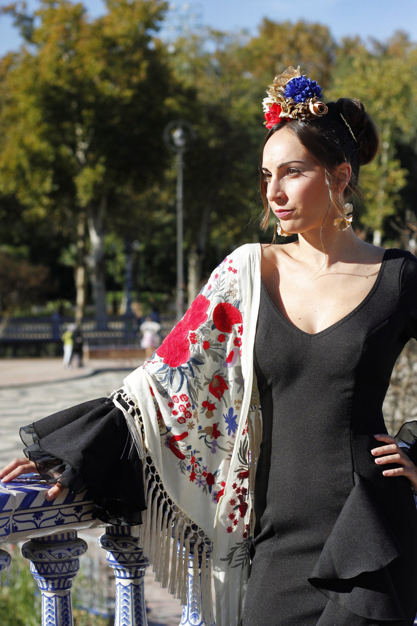 Sofisticado y artesanal, el manton beige Elena es el complemento ideal para tu traje de flamenca, con diseño floral en rojo y azul.