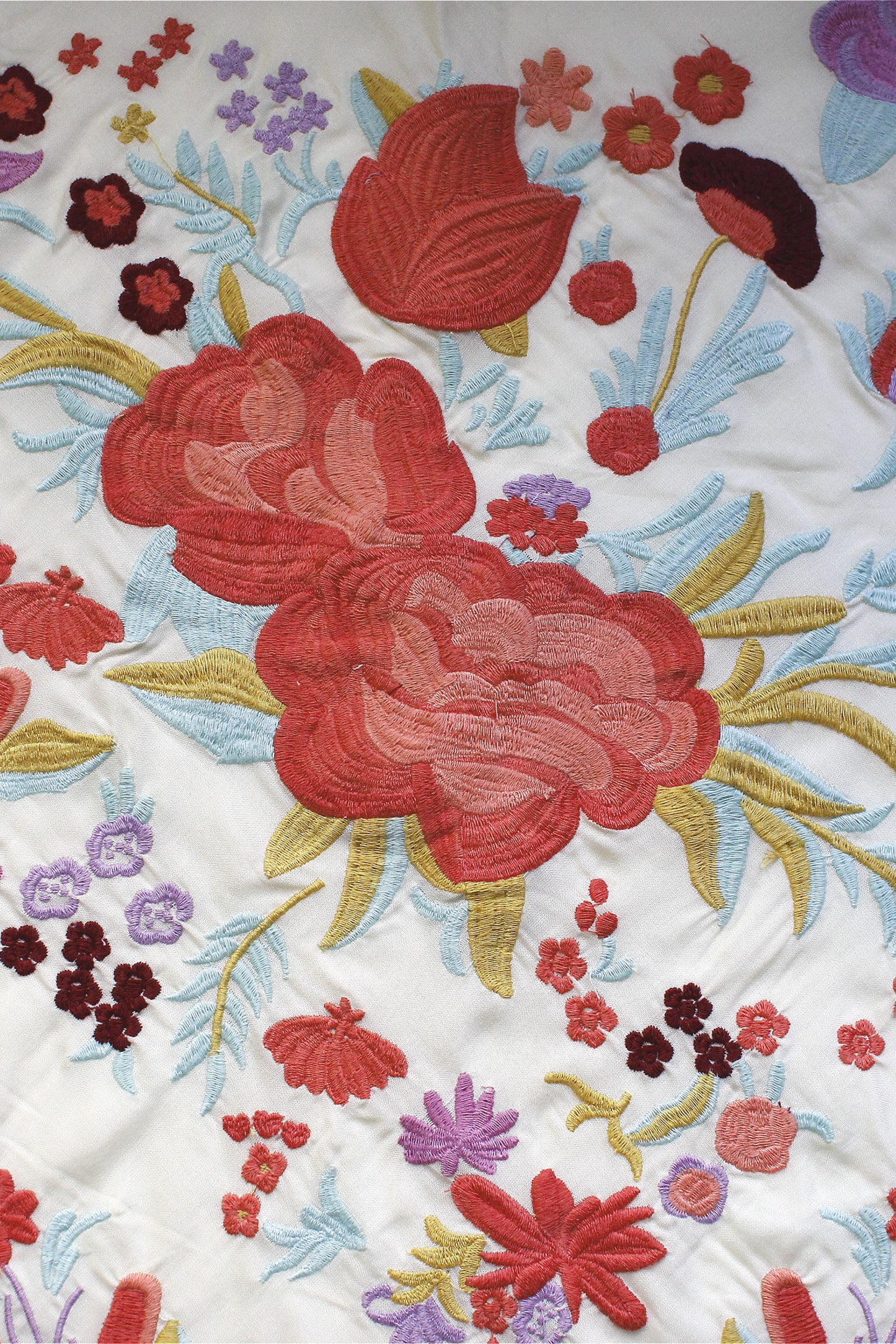 Resalta tu estilo flamenco con el manton beige Elena, diseñado en seda con vibrantes flores en naranja.