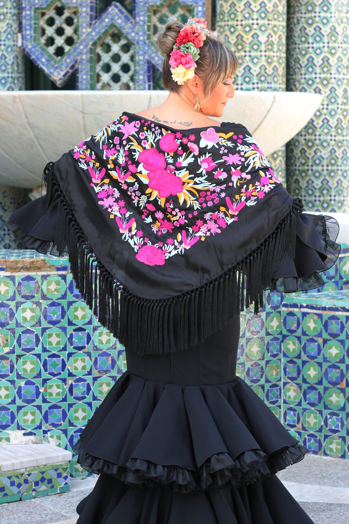 El manton negro Elena aporta sofisticacion y estilo con su diseño floral en tonos buganvilla. Perfecto para flamencas.