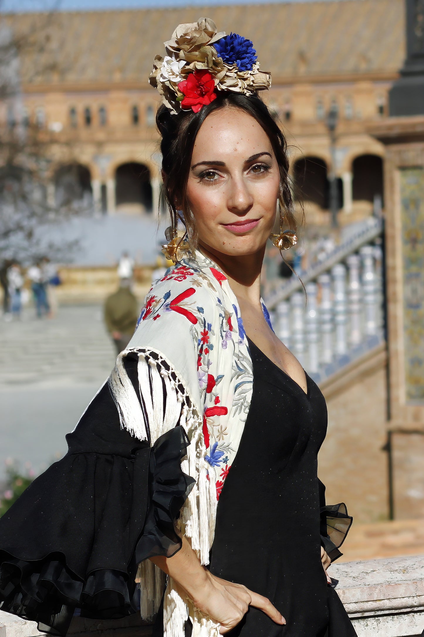 Con el ramillete de flores Bulería, confeccionado a mano en tonos beige, rojo y azul, tendrás el complemento perfecto para un look flamenco lleno de energía y originalidad en la feria o romerías.