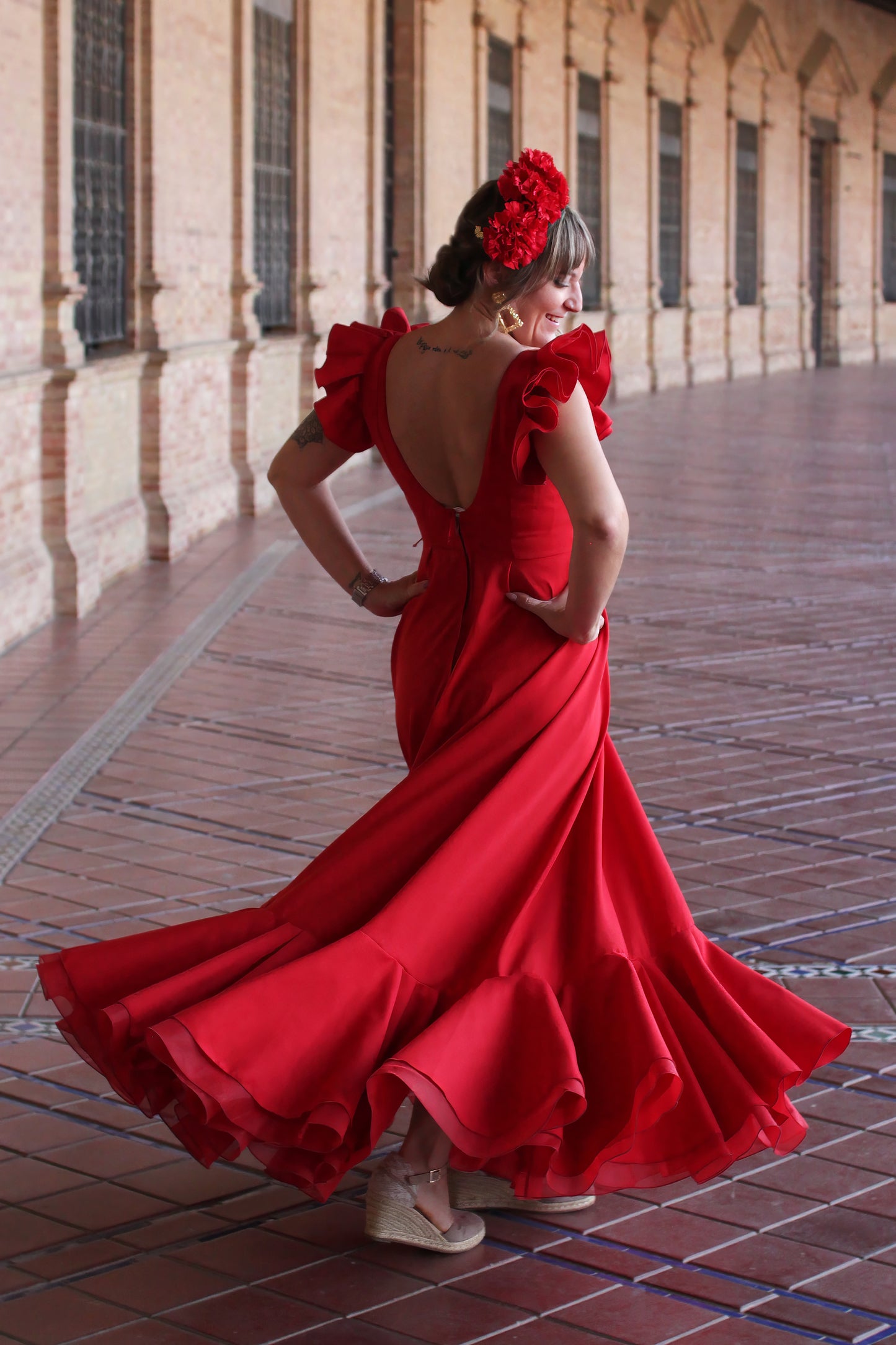 Bata Flamenca roja Girasol, ideal para días calurosos de feria, con un estilo flamenco fresco y vibrante.