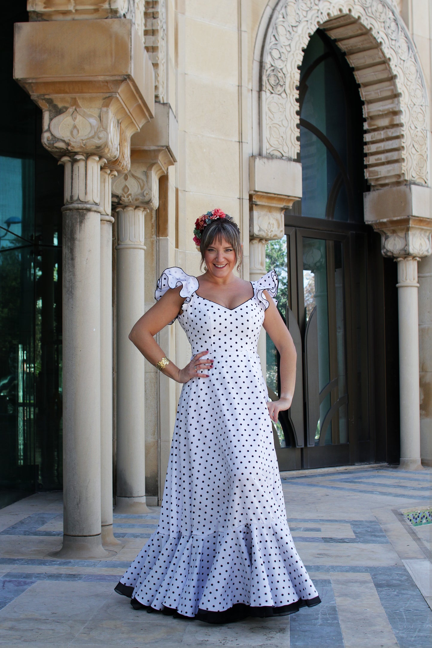 Bata flamenca blanca Girasol con estampado de lunares negros, perfecta para romerías y ferias, con un diseño cómodo y alegre.