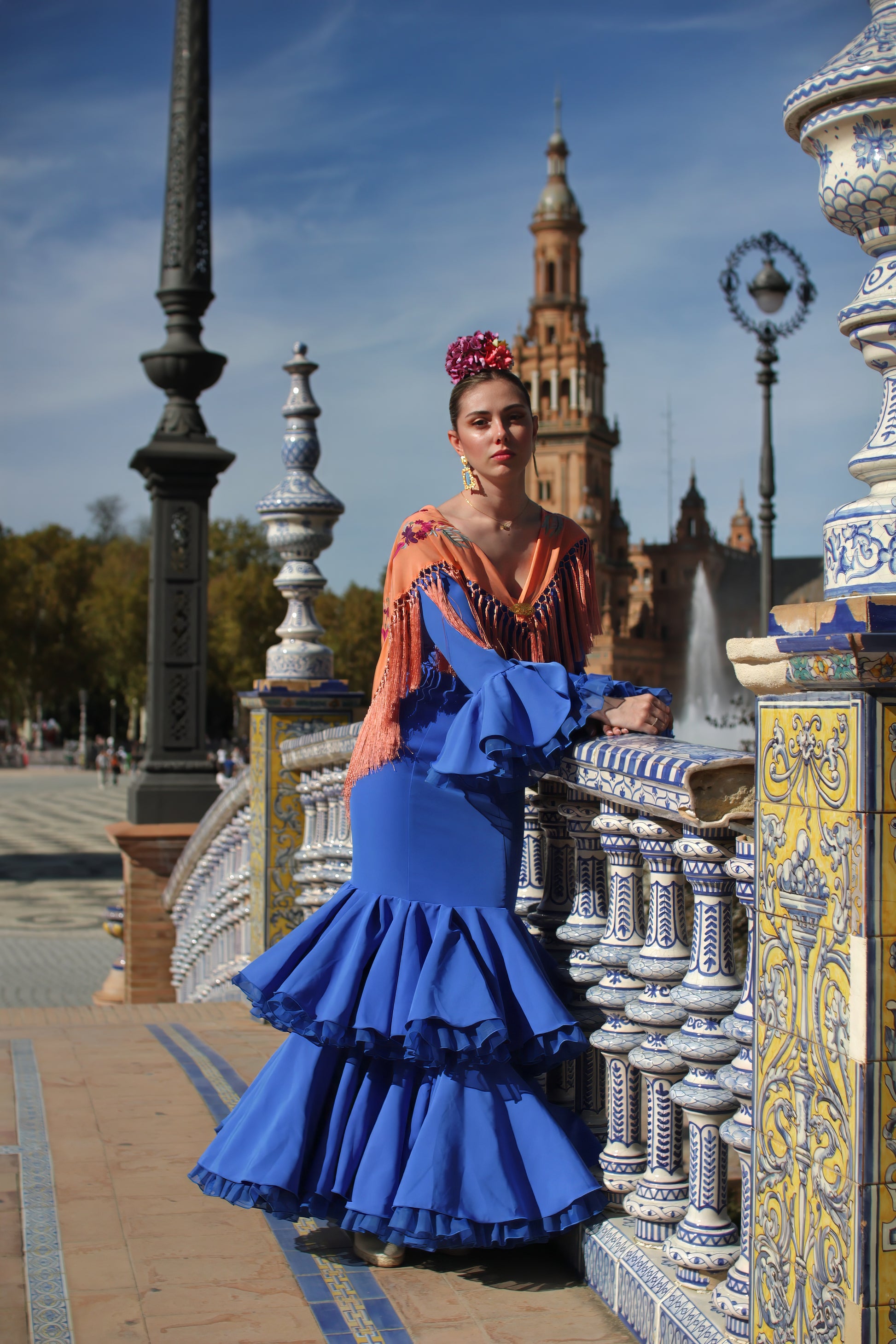 El look perfecto para la Feria de Abril: vestido azul Jazmin, manton mandarina, ramillete Jaleo y pendientes dorados Carmona. Todo lo que necesitas para brillar con estilo flamenco.