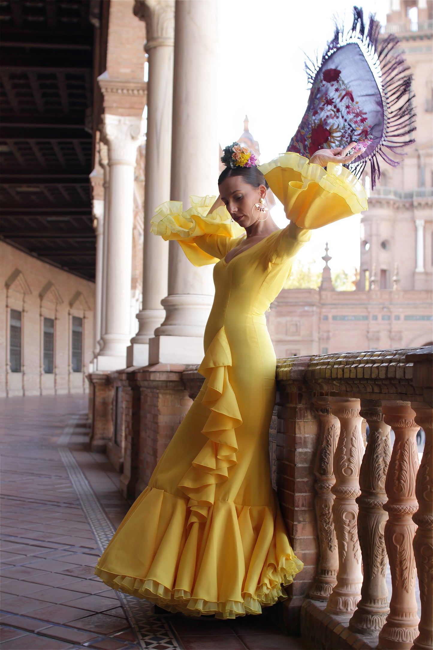 Viste con estilo para la Feria de Abril: traje de flamenca amarillo Azahar, mantón morado, ramillete de flores Brisa y pendientes dorados Jara. Look completo, vibrante y elegante.
