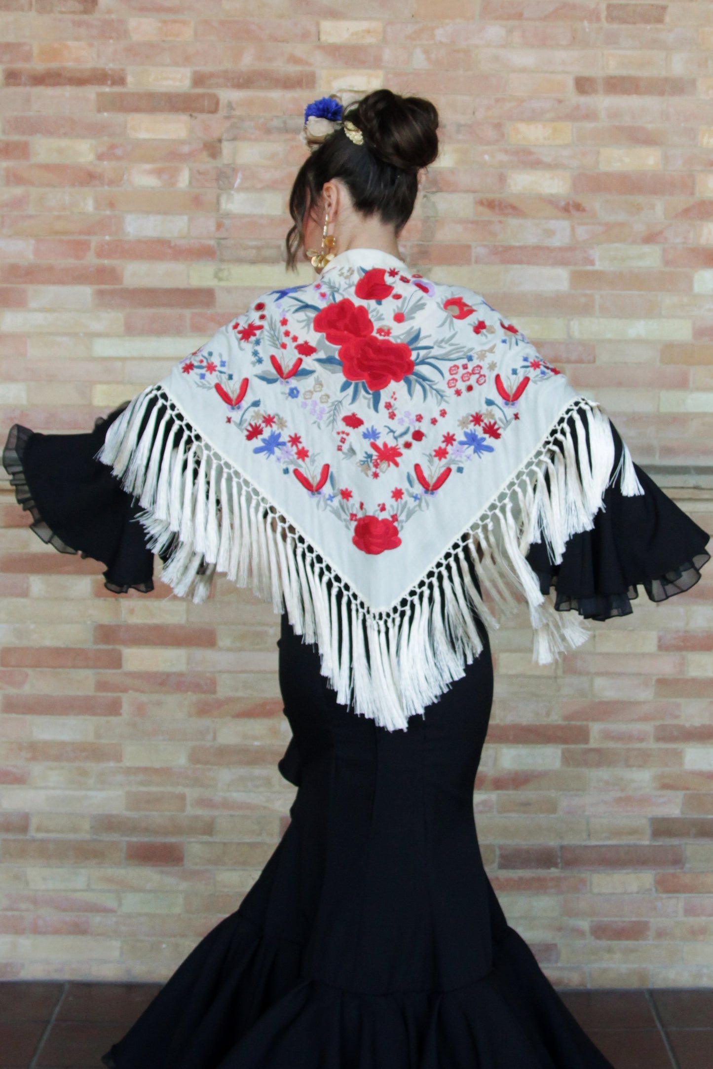 Añade elegancia a tu traje de flamenca con el manton beige Elena, diseño floral en rojo y azul con flecos de seda.