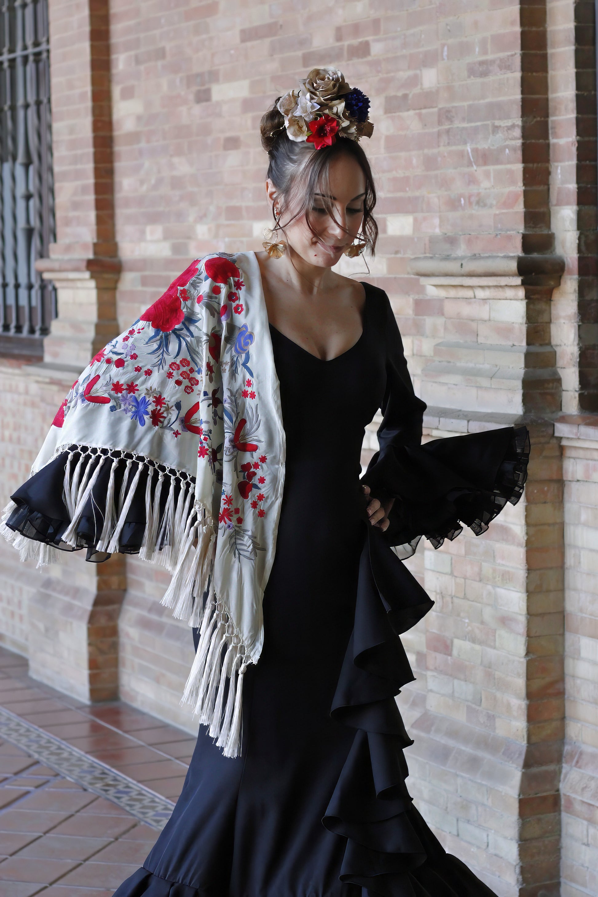 Perfecto para ferias y romerías, el manton beige Elena combina sofisticación y tradición con su diseño floral en rojo y azul.