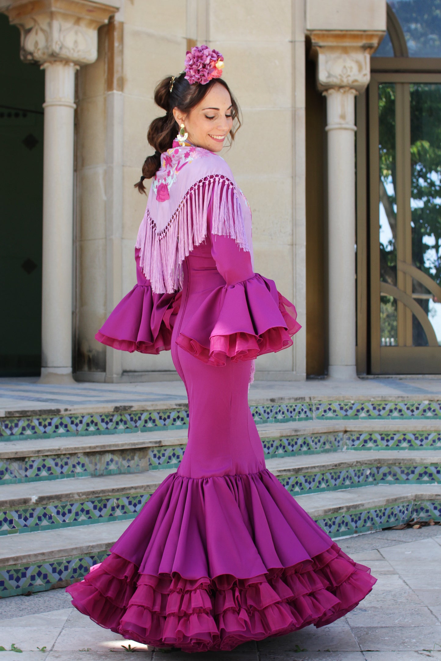 El manton de flamenca Elena en lila con flores buganvilla y amarillo es un accesorio tradicional y sofisticado. Elaborado en Cantillana, aporta un toque de distinción a tu traje.