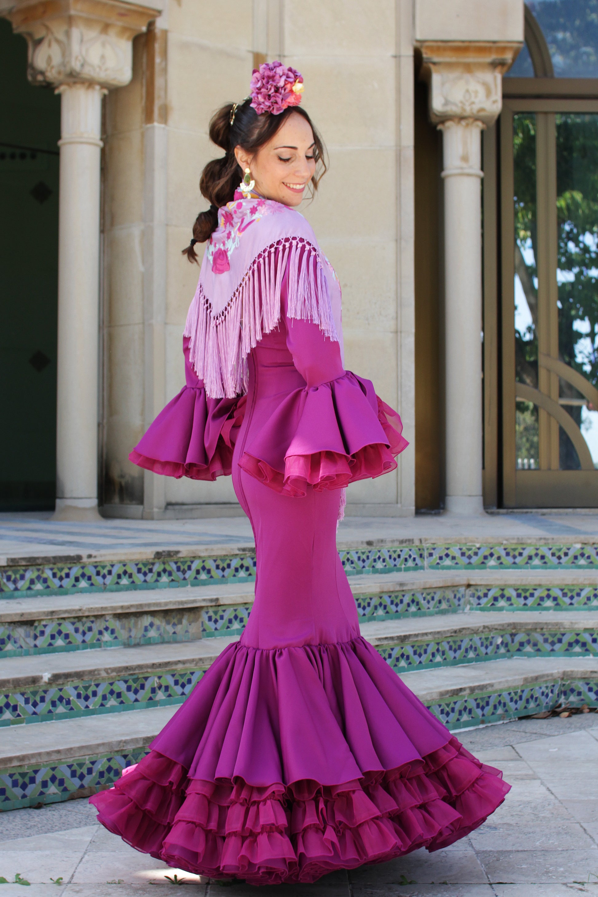 El manton de flamenca Elena en lila con flores buganvilla y amarillo es un accesorio tradicional y sofisticado. Elaborado en Cantillana, aporta un toque de distinción a tu traje.