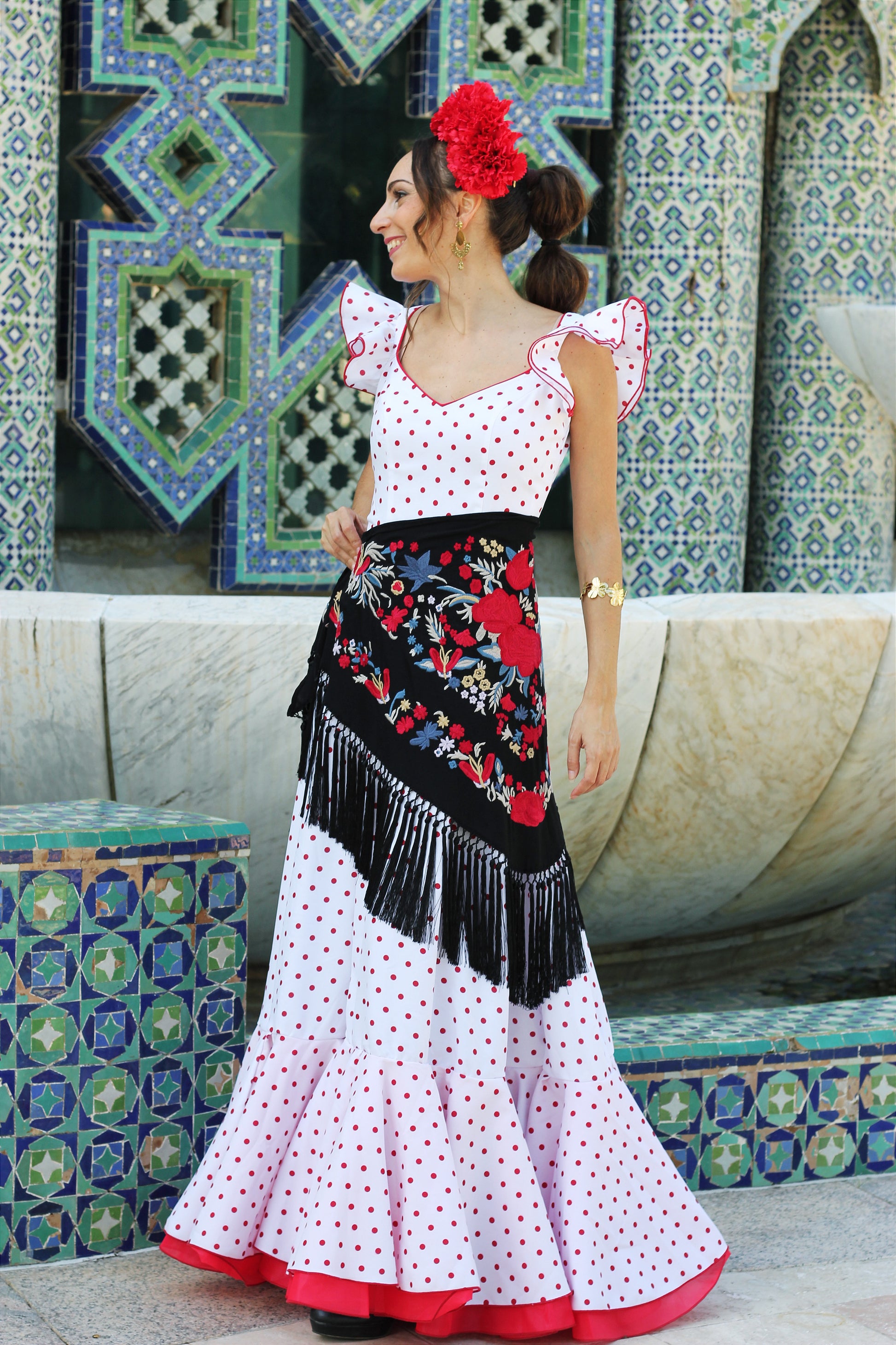 Realza tu traje de flamenca con el manton negro Noa, diseñado con flores en rojo y azul, confeccionado en algodón con flecos de seda.