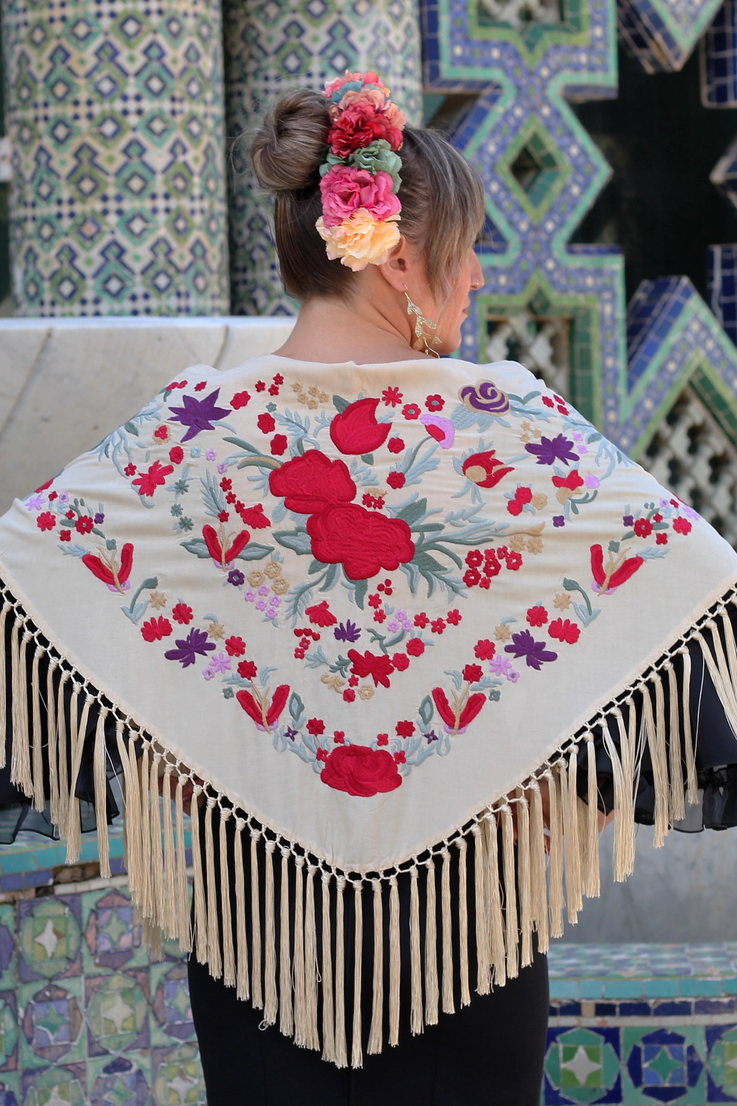 El manton beige Noa, con flores rojas y moradas, es el complemento perfecto para un look flamenco vibrante y lleno de color.