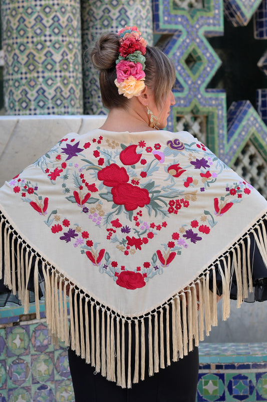 El manton beige Noa, con flores rojas y moradas, es el complemento perfecto para un look flamenco vibrante y lleno de color.
