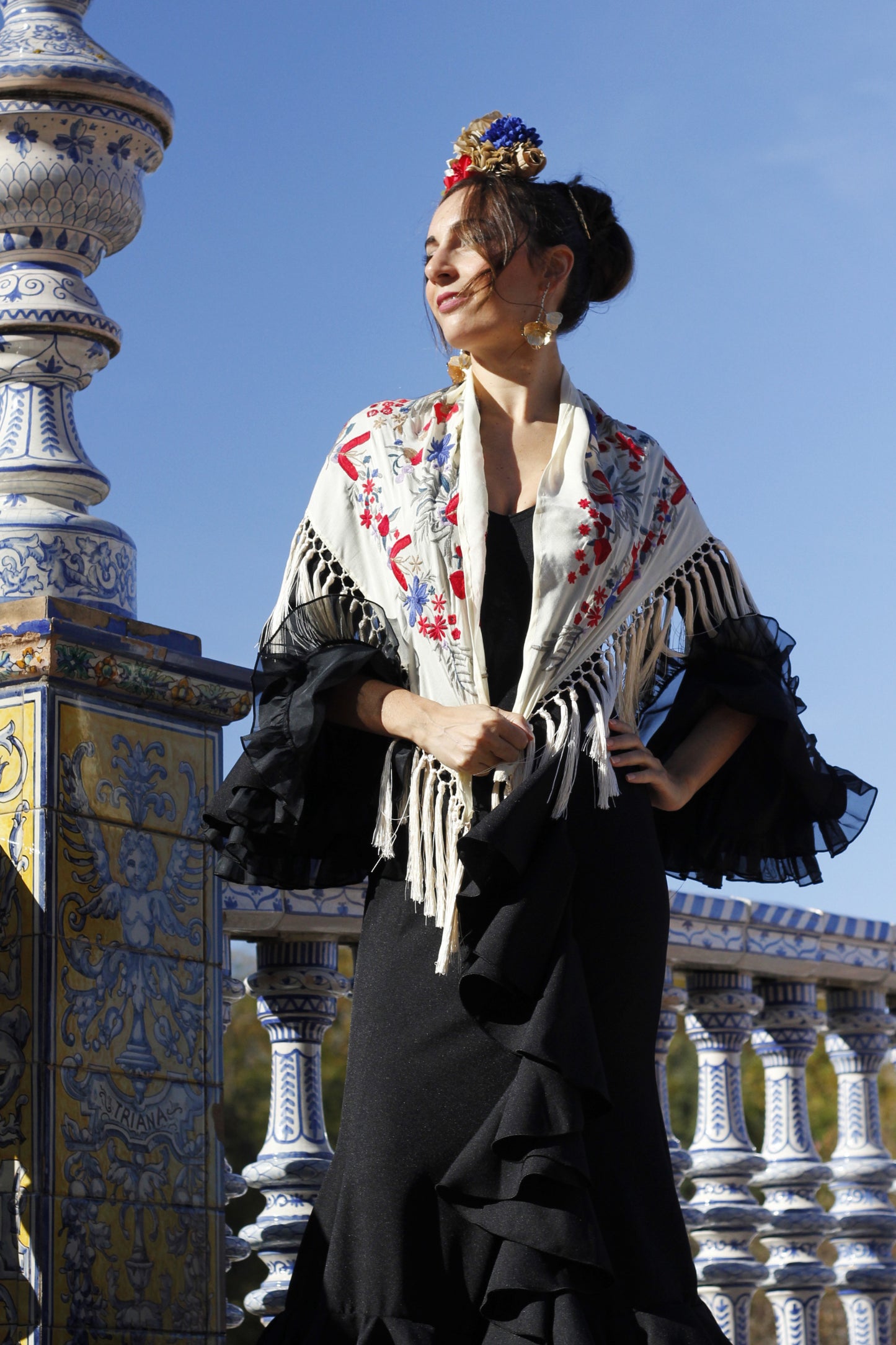 Completa tu look con el manton Elena en tono beige, un accesorio ideal con diseño floral rojo y azul.