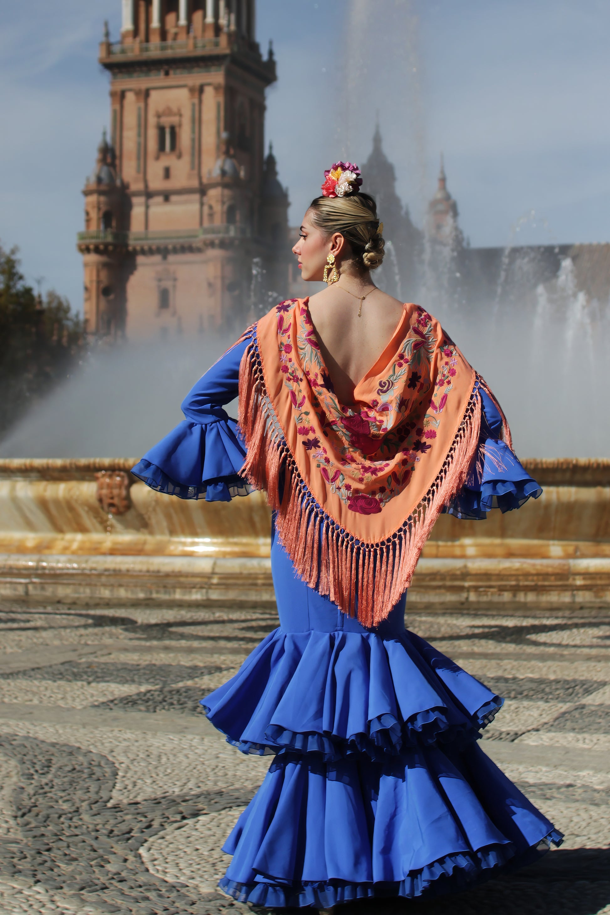 Descubre el manton de flamenca mandarina Noa, elaborado en algodón con flecos de seda y diseño floral buganvilla. Perfecto para añadir estilo y alegría a tu look flamenco.
