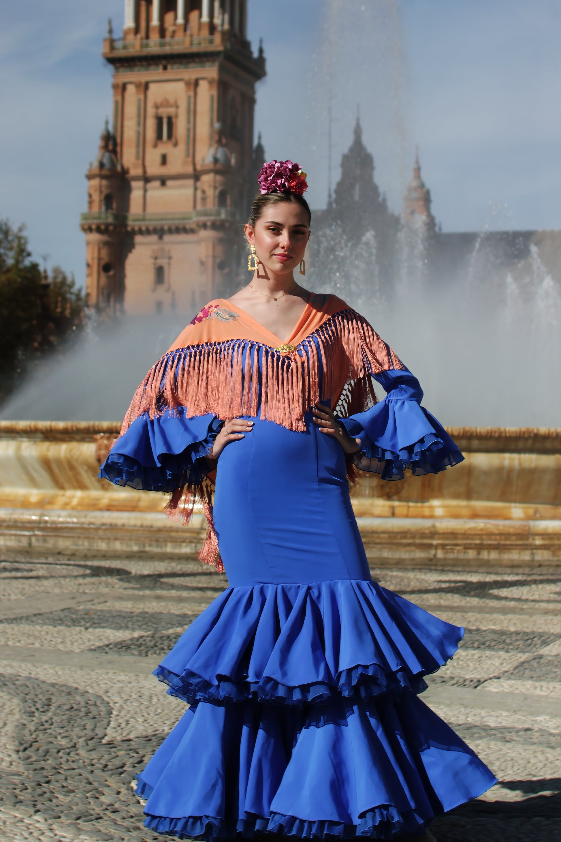 El manton de flamenca mandarina Noa, con diseño floral buganvilla y flecos de seda, es una pieza artesanal que combina tradición y estilo flamenco.