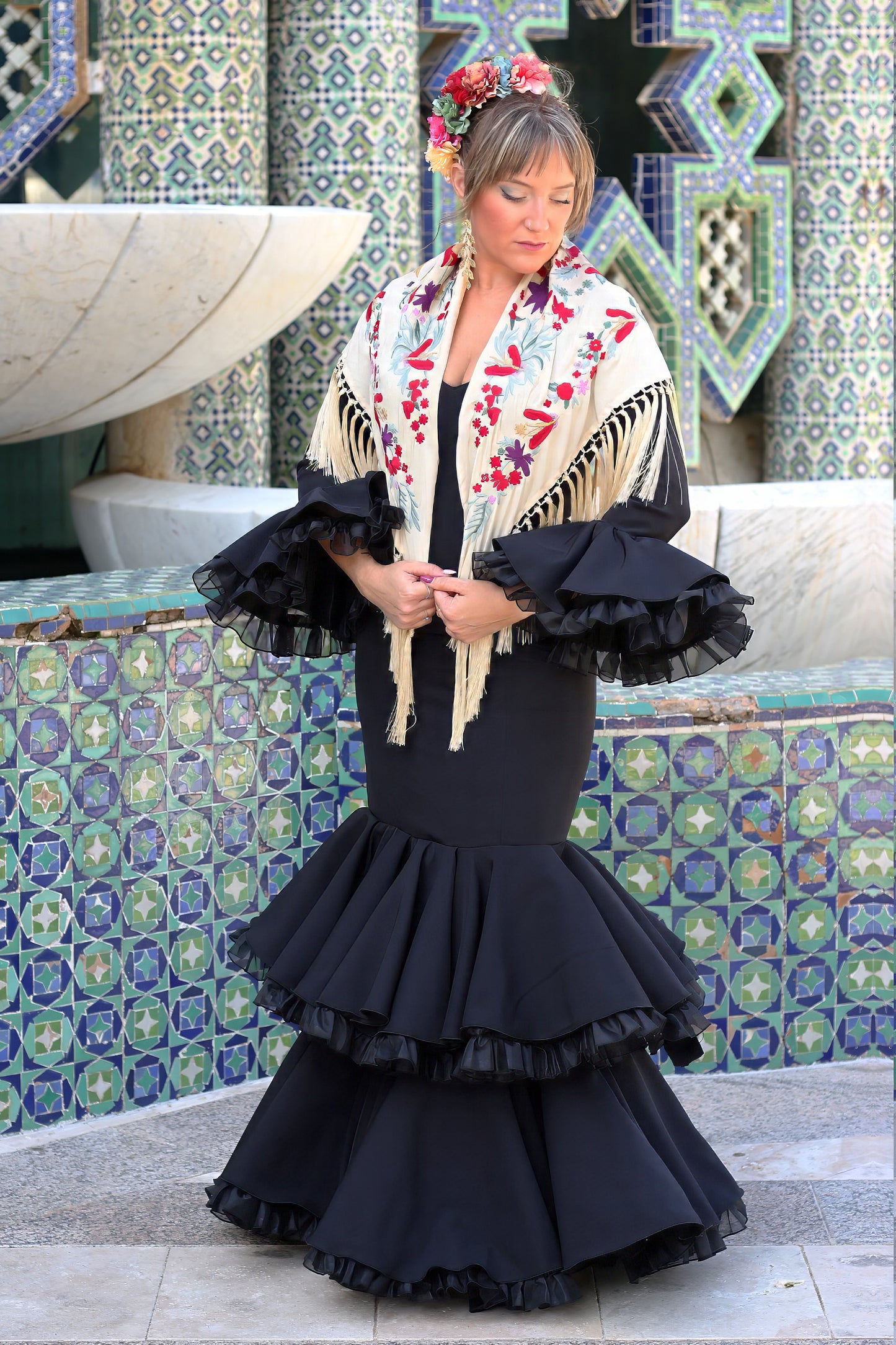 Añade un toque de color a tu estilo flamenco con el manton beige Noa, diseñado con flores rojas y moradas.