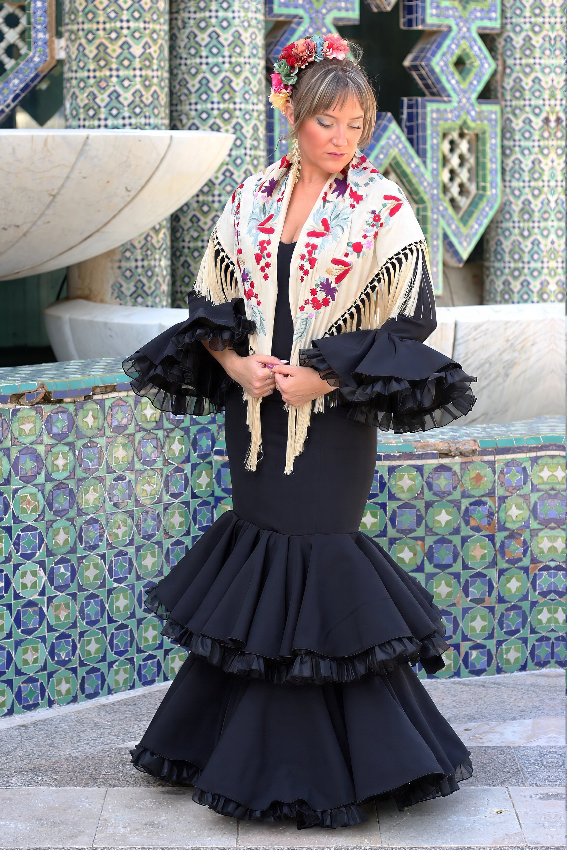 Añade un toque de color a tu estilo flamenco con el manton beige Noa, diseñado con flores rojas y moradas.