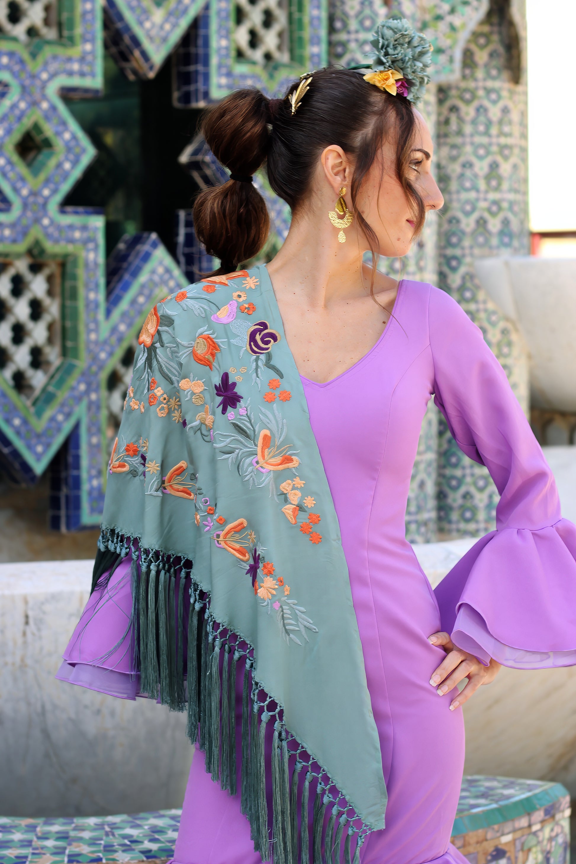 Resalta tu look flamenco con el mantón verde jabonoso Noa, con un diseño floral en naranja y morado que combina frescura y estilo vibrante.