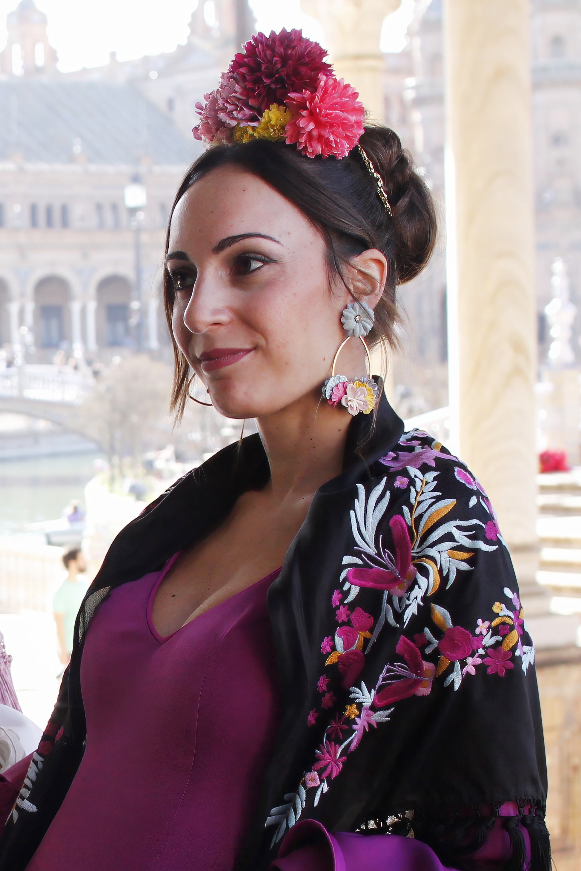 Los pendientes de flamenca Almonte combinan flores coloridas sobre un aro dorado, creando un diseño sofisticado y original que resalta tu estilo flamenco.