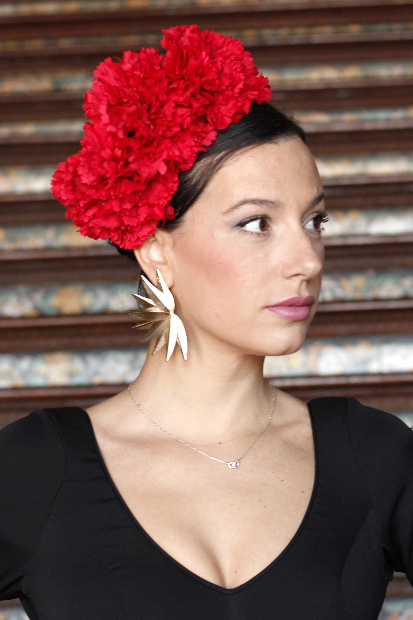 Los pendientes Hinojos, con su elegante diseño floral puntiagudo en dorado, son el accesorio perfecto para aportar sofisticación y glamour a tu look flamenco.