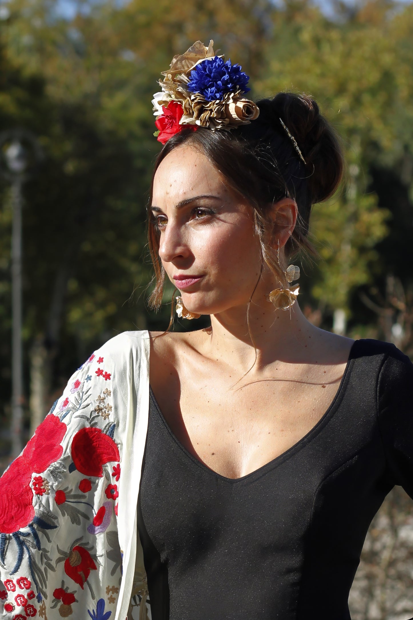 Con el ramillete Bulería en tonos beige, rojo y azul, añade un toque vibrante a tu look flamenco. Hecho a mano, este ramillete es perfecto para destacar en tus eventos más especiales.