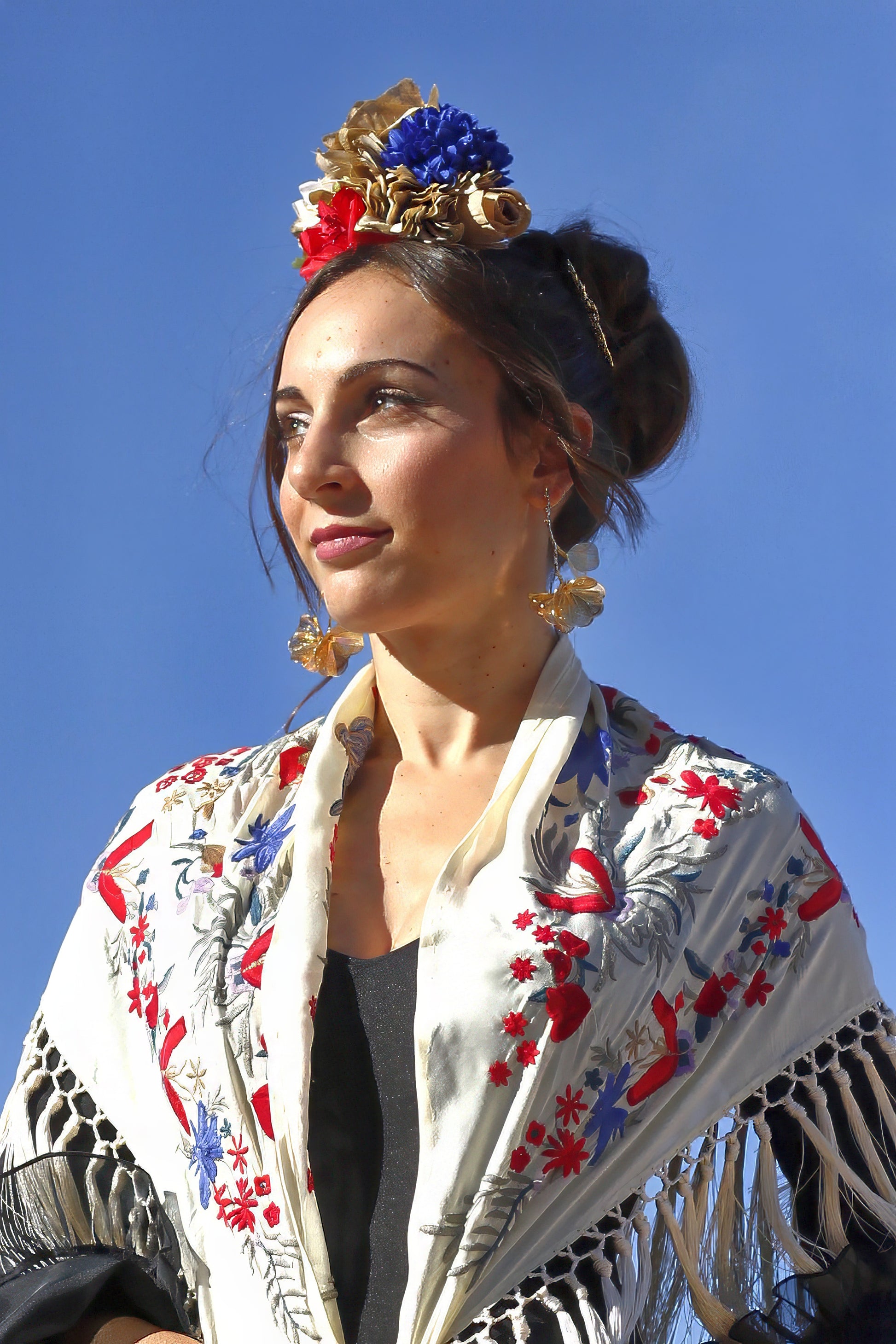 El ramillete Bulería combina tonos beige, rojo y azul para crear un complemento flamenco único. Perfecto para destacar en eventos como la Feria de Abril o romerías, con un diseño artesanal que resalta la esencia flamenca.