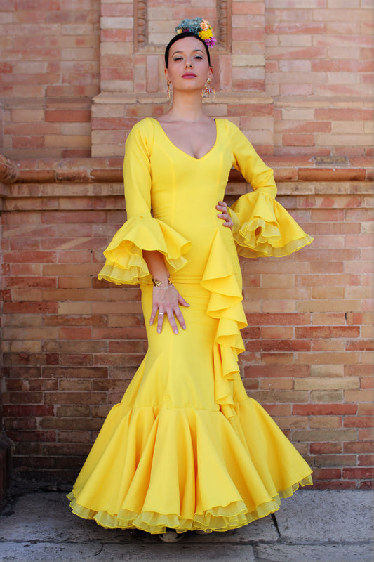 Traje de flamenca amarillo Azahar, diseño con volante vertical, tres capas para un vuelo espectacular y escote en V, ideal para la Feria de Abril y romerías.