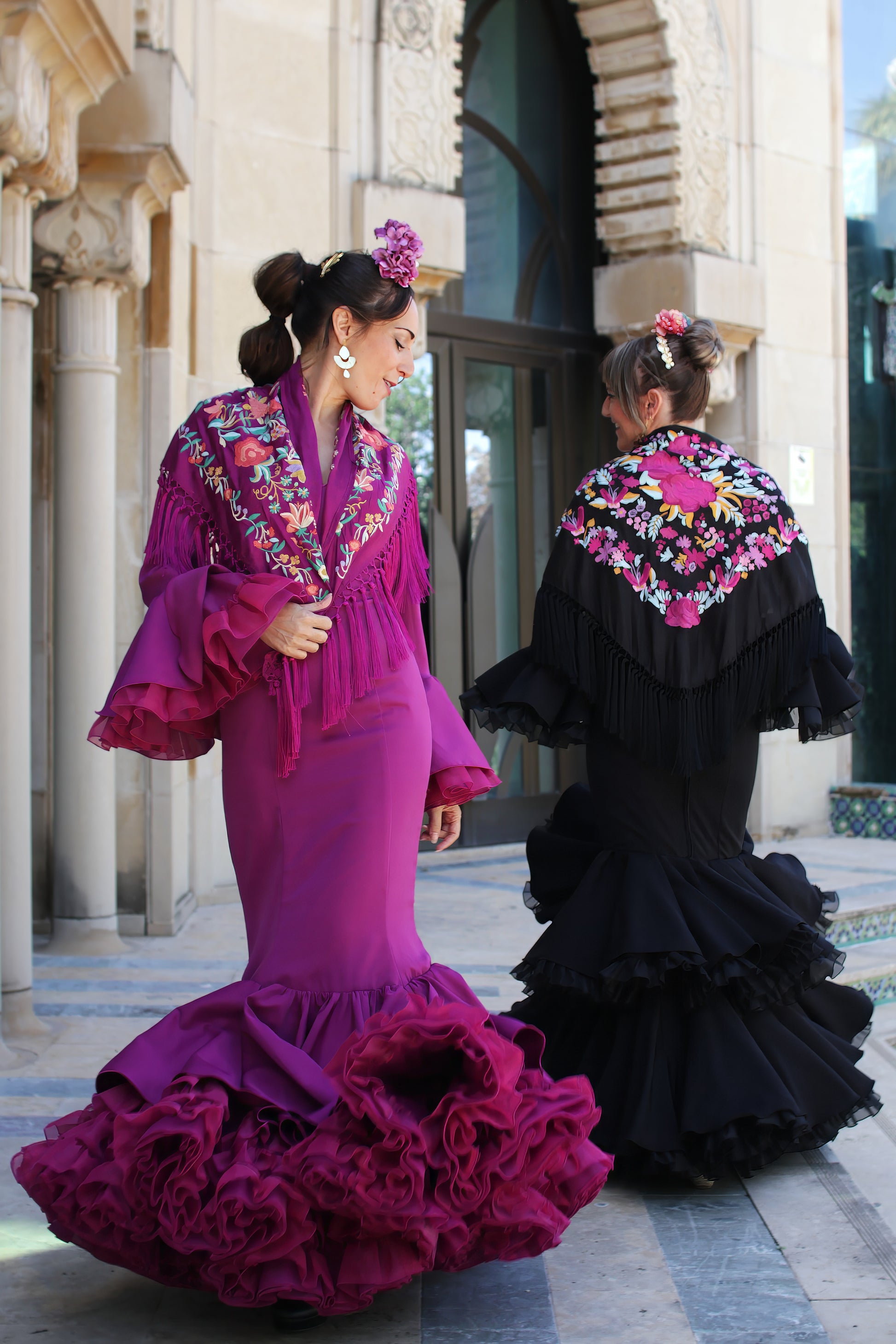 Trajes de flamenca Clavel en buganvilla y negro, con diseño de volantes, tejido de licra y corte sirena, ideales para looks flamencos en pareja.