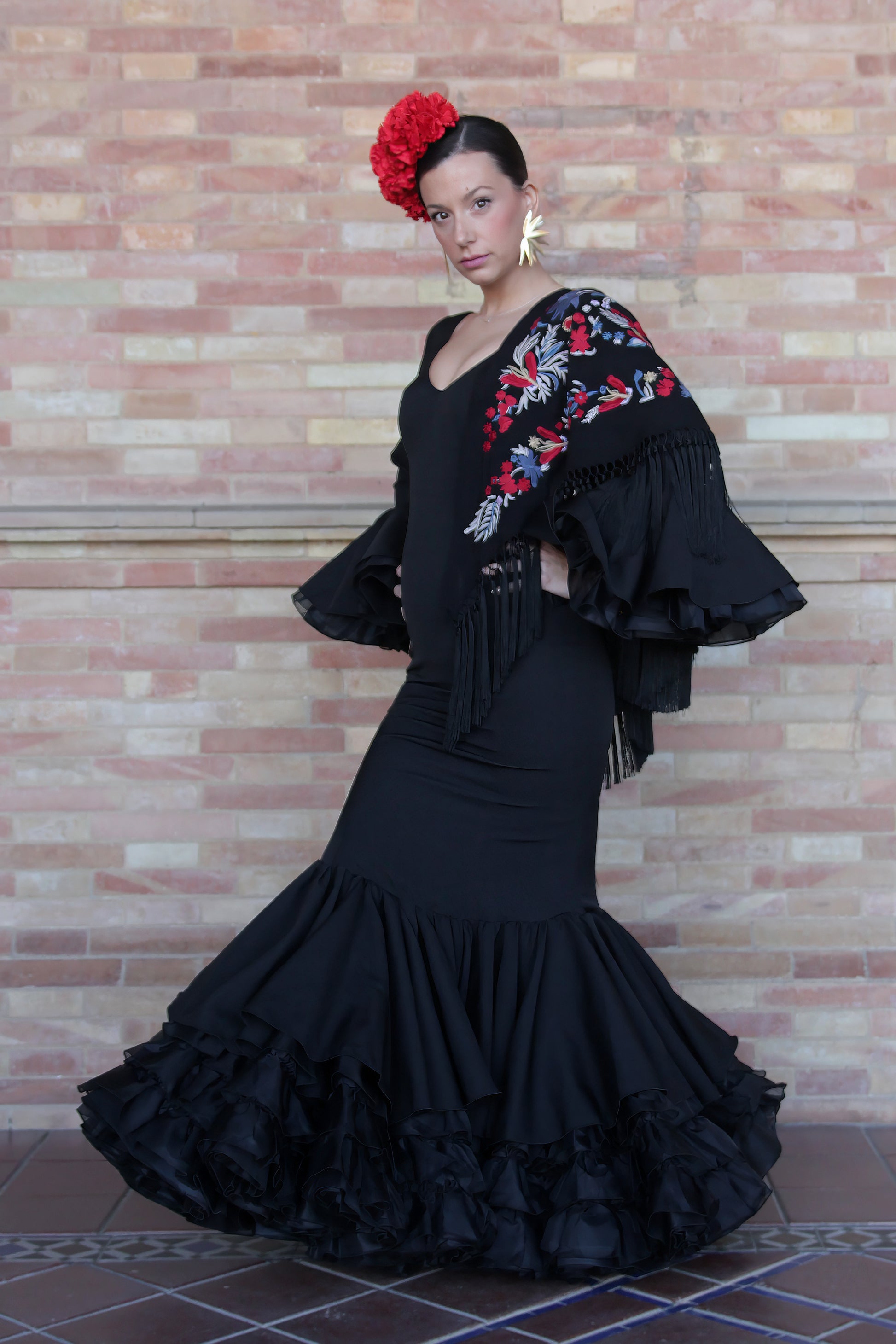 Traje de flamenca negro Clavel, con ajuste perfecto al cuerpo, tejido de licra y volantes que destacan en cada movimiento.